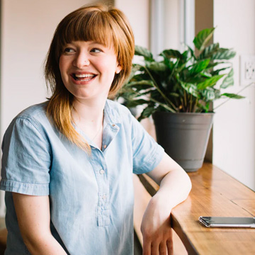 Smiling business woman sat next to a window